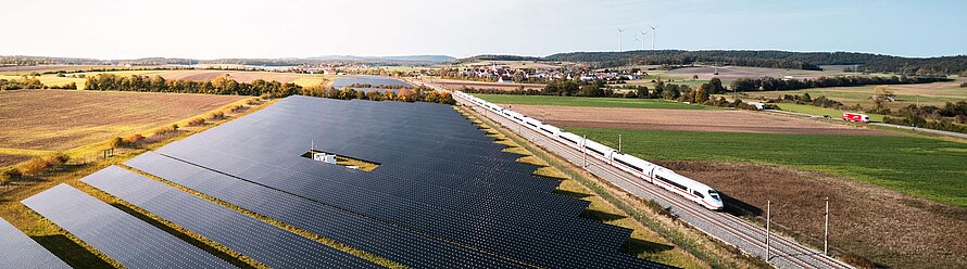 Photovoltaikfreiflächenanlage mit ICE und Windkraft im hintergrund bei Markt Bibart