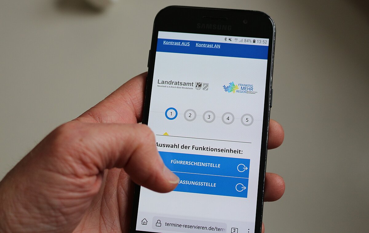 Blick auf Handydisplay, Terminbuchung ist geöffnet