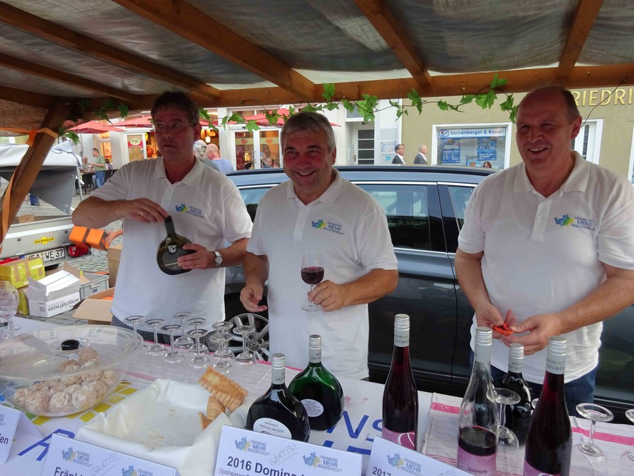 Zwei Mitarbeiter des Landratsamtes Neustadt a.d.Aisch-Bad Windsheim betreuen einen Weinstand