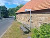 Bank mit Schild "Mitfahrbank" vor einer Hauswand