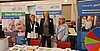 Messestand mit vier Informationsbannern und drei Frauen hinter einem Tisch mit Broschüren – Themen sind Seniorenversorgung, Wohnraumberatung und Gesundheitsregionplus im Rahmen regionaler Sozial- und Gesundheitsangebote.