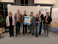 Bayerns Wirtschaftsstaatssekretär Tobias Gotthardt (4. v. l.) bei der Übergabe des Förderbescheids.