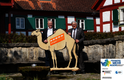 Bürgermeister von Markt Nordheim und Landrat mit dem "Maskottchen" der Energiekarawane, einem Kamel